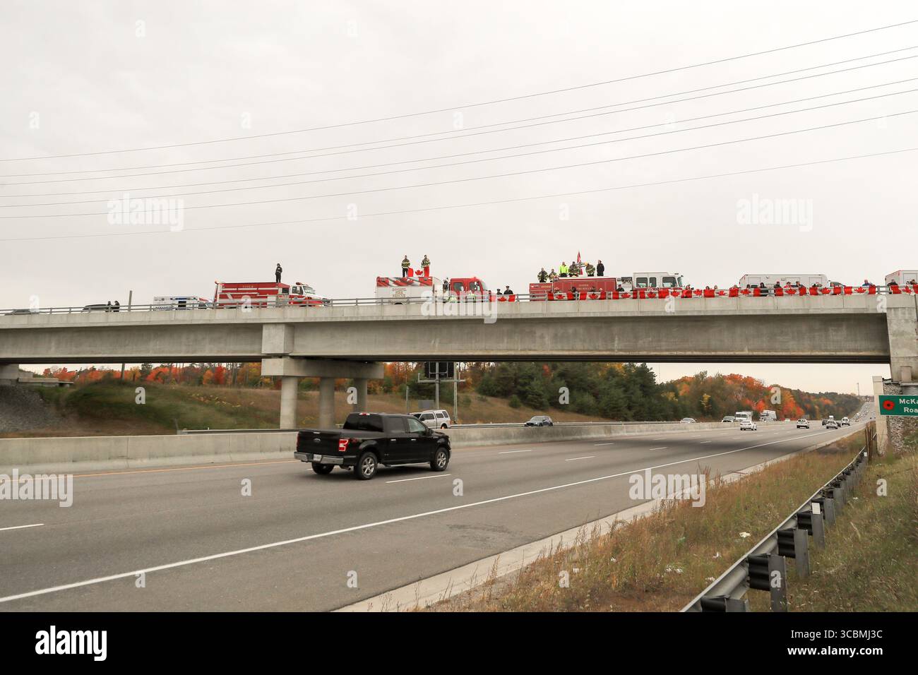14 ottobre 2022, Innisfil, Ontario, Canada: Servizi di emergenza e bandiere canadesi pubbliche sul cavalcavia McKay Road Highway 400 preparandosi a salutare la processione di due agenti della polizia di South Simcoe uccisi che hanno risposto a una chiamata di disturbo domestica ad Alcona (Innisfil), Ontario - una piccola città nel centro-sud dell'Ontario, a circa un'ora a nord di Toronto. (Immagine di credito: © Christopher Drost/SHIFT digital tramite ZUMA Press Wire) Foto Stock