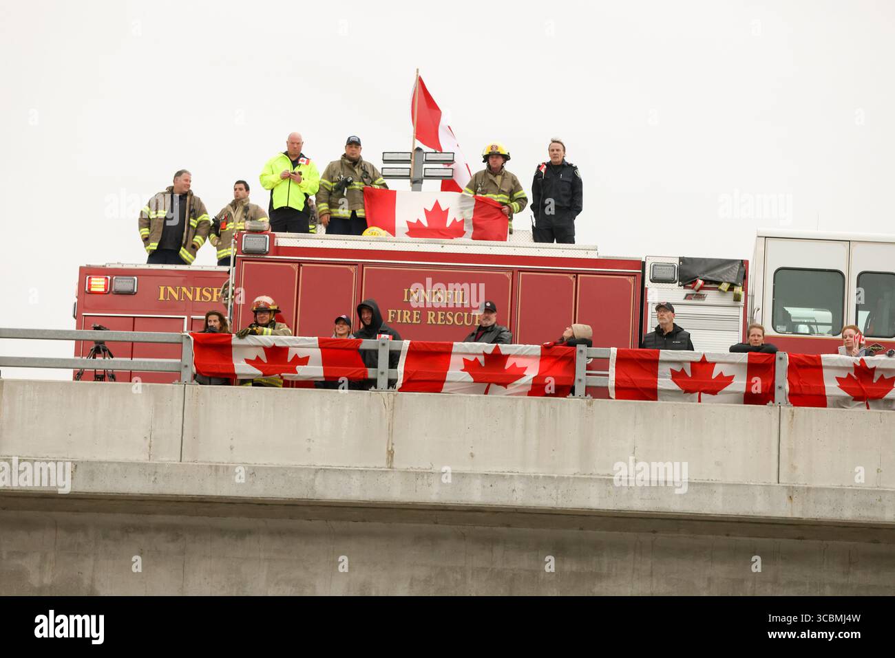 14 ottobre 2022, Innisfil, Ontario, Canada: Servizi di emergenza e bandiere canadesi pubbliche sul cavalcavia McKay Road Highway 400 preparandosi a salutare la processione di due agenti della polizia di South Simcoe uccisi che hanno risposto a una chiamata di disturbo domestica ad Alcona (Innisfil), Ontario - una piccola città nel centro-sud dell'Ontario, a circa un'ora a nord di Toronto. (Immagine di credito: © Christopher Drost/SHIFT digital tramite ZUMA Press Wire) Foto Stock