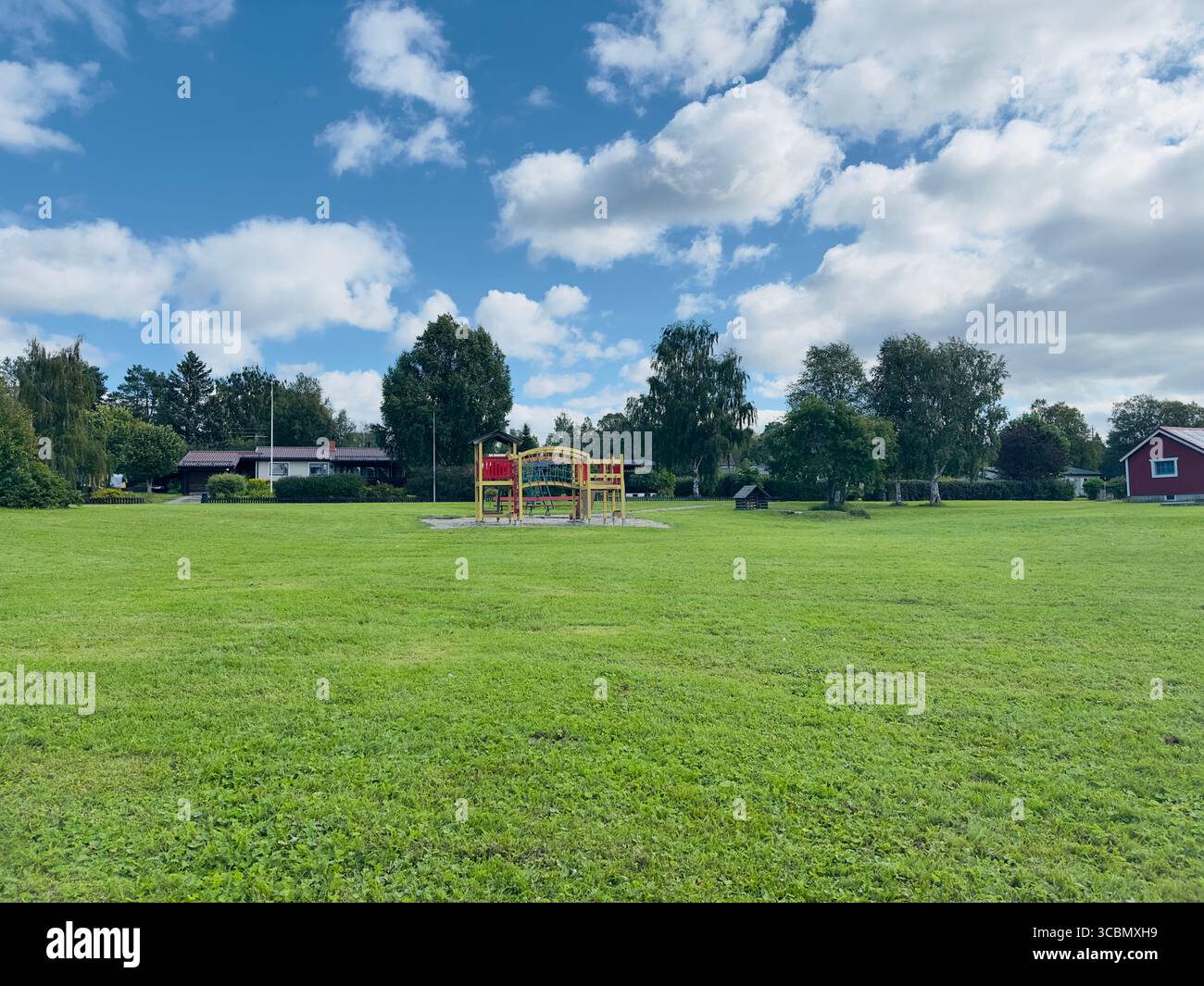 Una bella giornata di sole al parco con parco giochi e erba verde. - Immagine stock catturata con smartphone