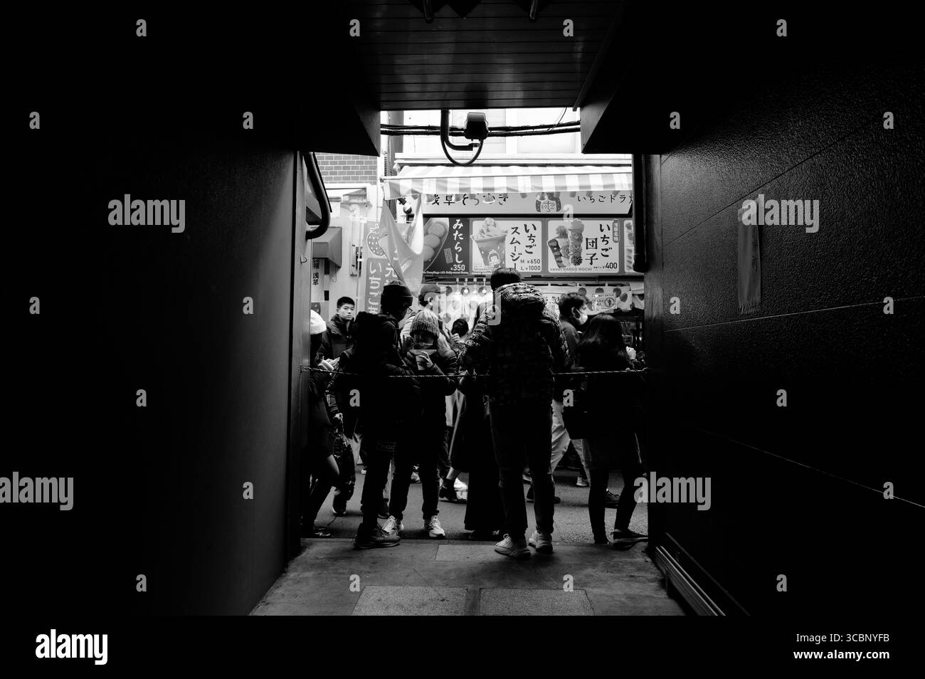 Figure sagomate di fronte a un negozio di dessert nella via dello shopping Nakamise in b&W Foto Stock