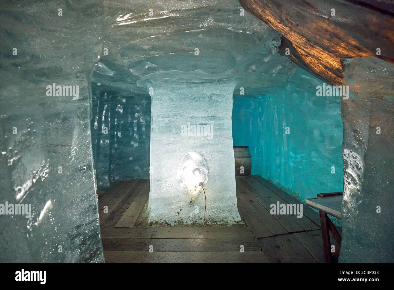 Un affascinante spazio modellato dal ghiaccio, che mostra tonalita' blu traslucide e pavimenti in legno. L'illuminazione soffusa mette in risalto le pareti ghiacciate, creando un effetto sontuoso Foto Stock
