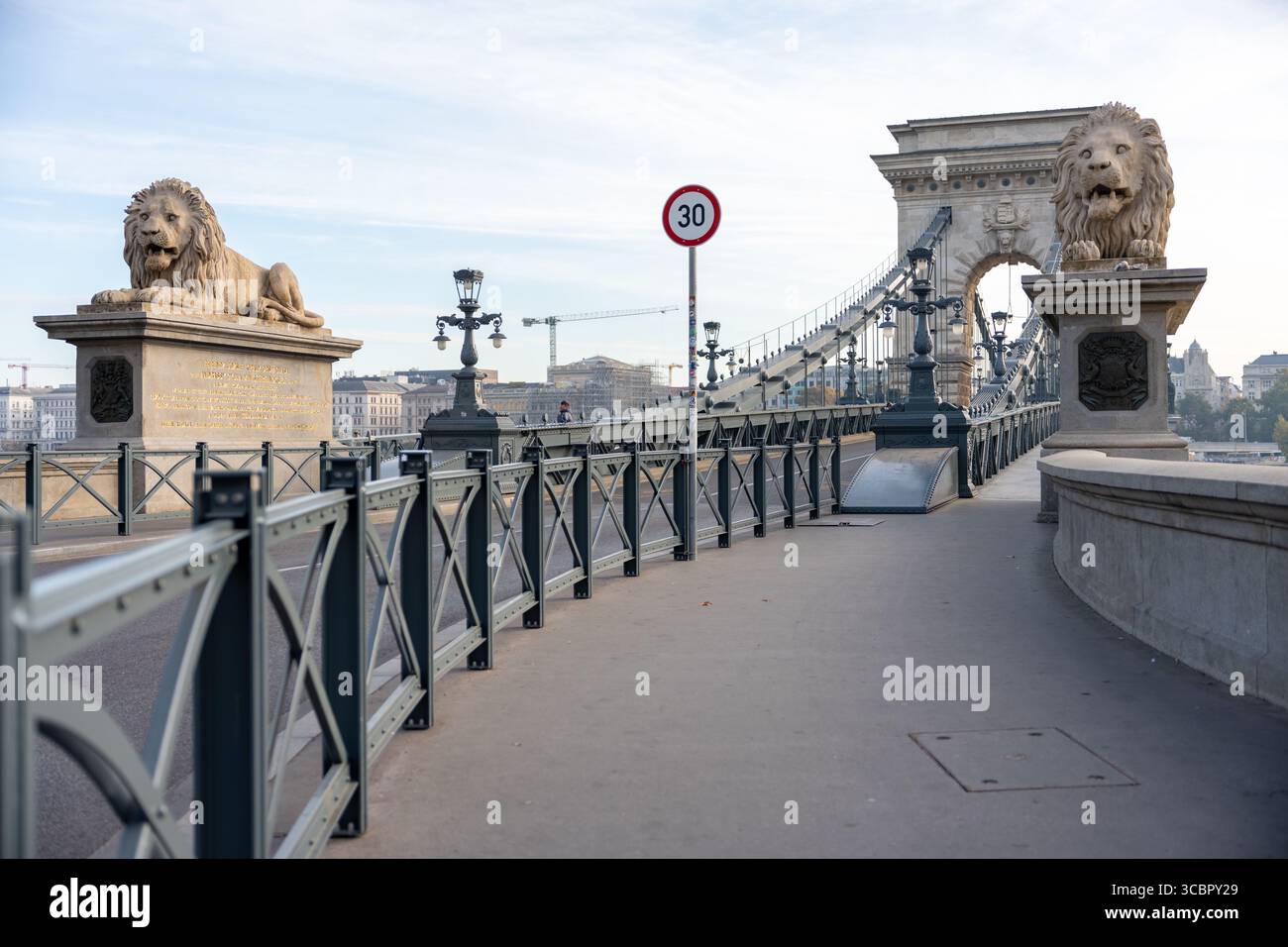 Ponte delle catene di Budapest durante il giorno con importanti statue di leoni e vuoto e isolato, che mette in risalto la storica architettura europea ungherese Foto Stock