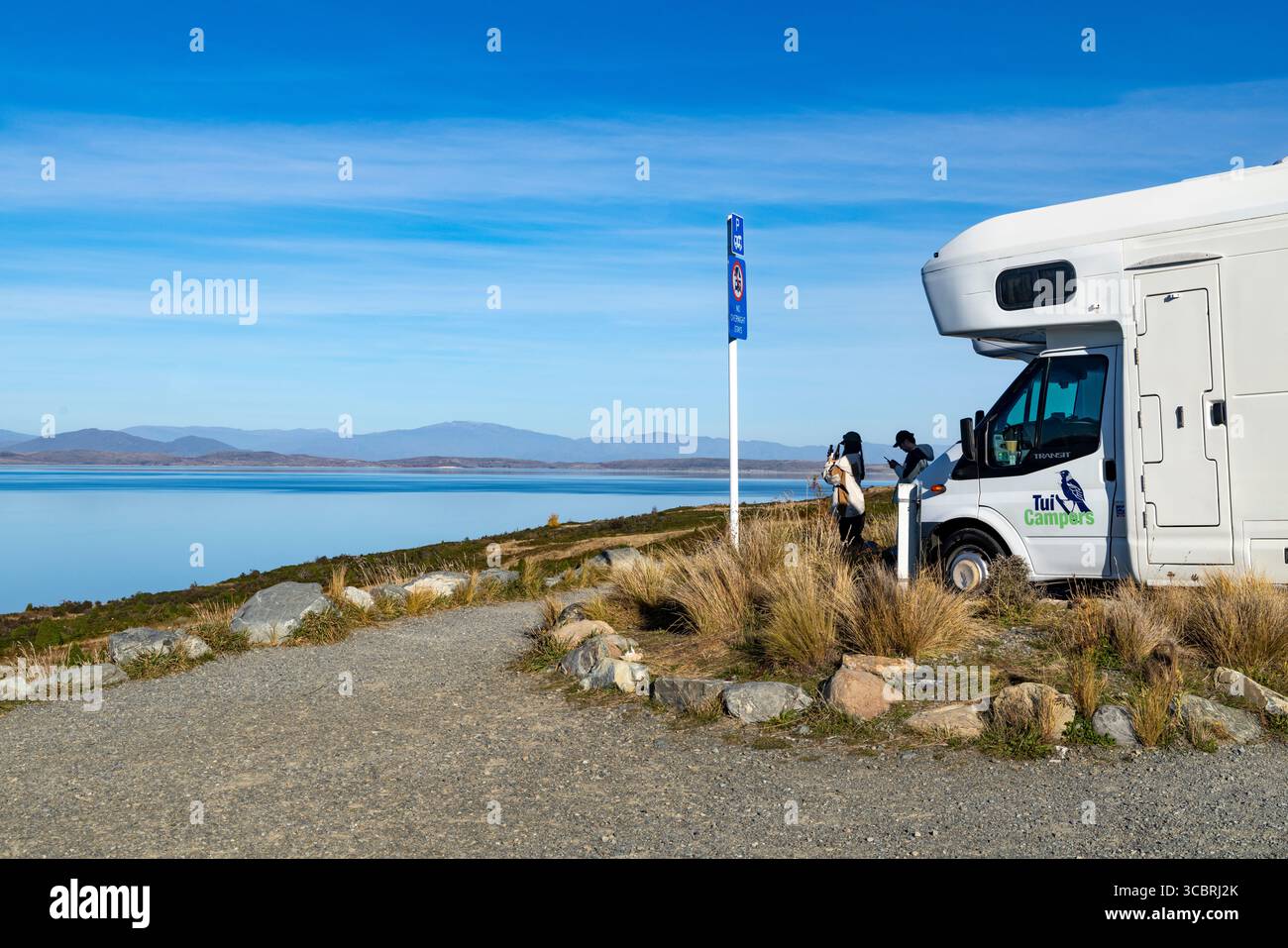 Lago Pukaki, bacino di Mackenzie, nuova Zelanda, coppia con il loro camper sosta al punto panoramico Peters per vedere questo lago alpino in un giorno d'autunno con cielo blu Foto Stock
