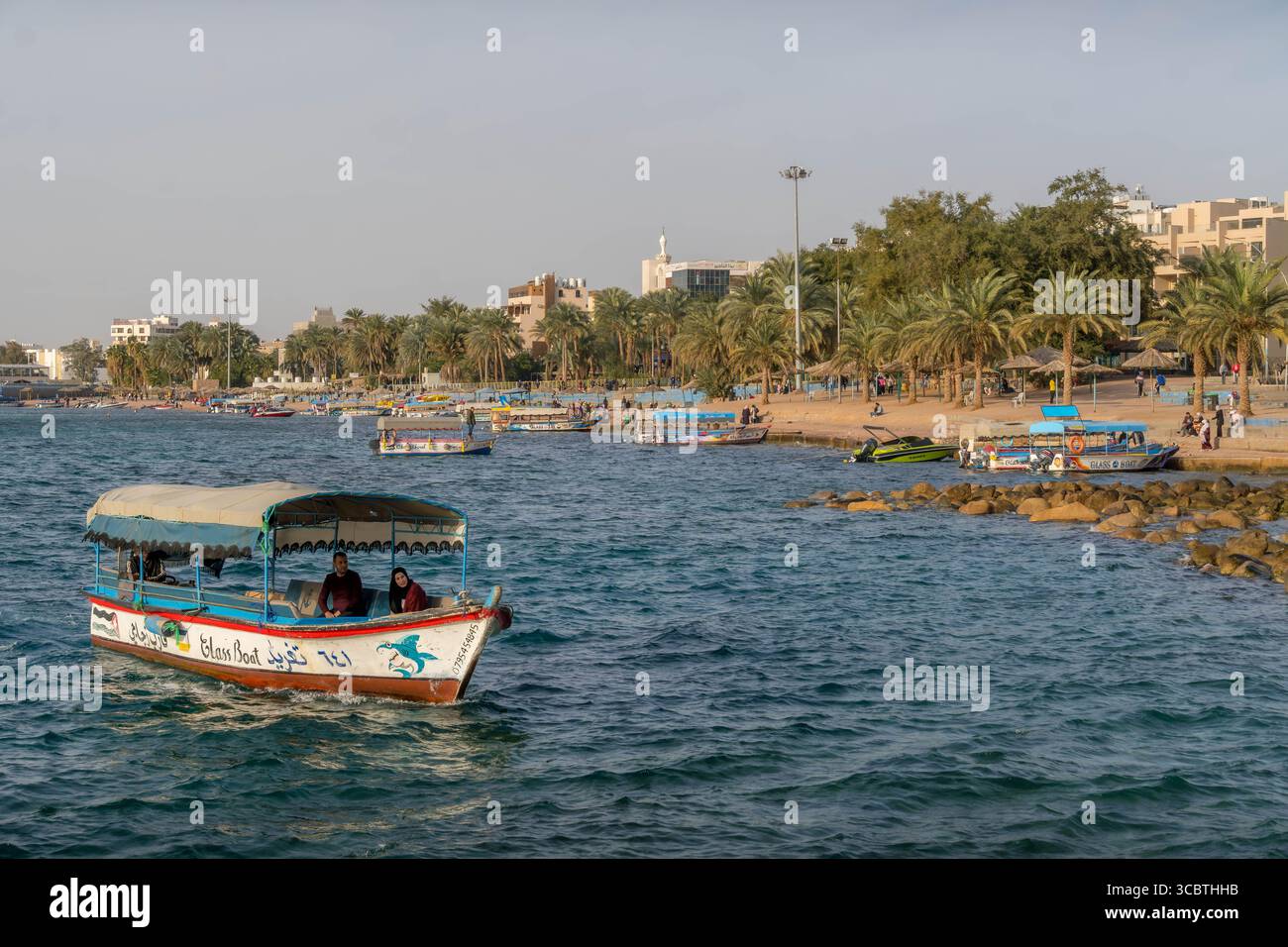 La costa di Aqaba sul Mar Rosso, in Giordania, è animata da barche da crociera, un popolare luogo turistico mediorientale con acque cristalline e vivaci attività marine Foto Stock