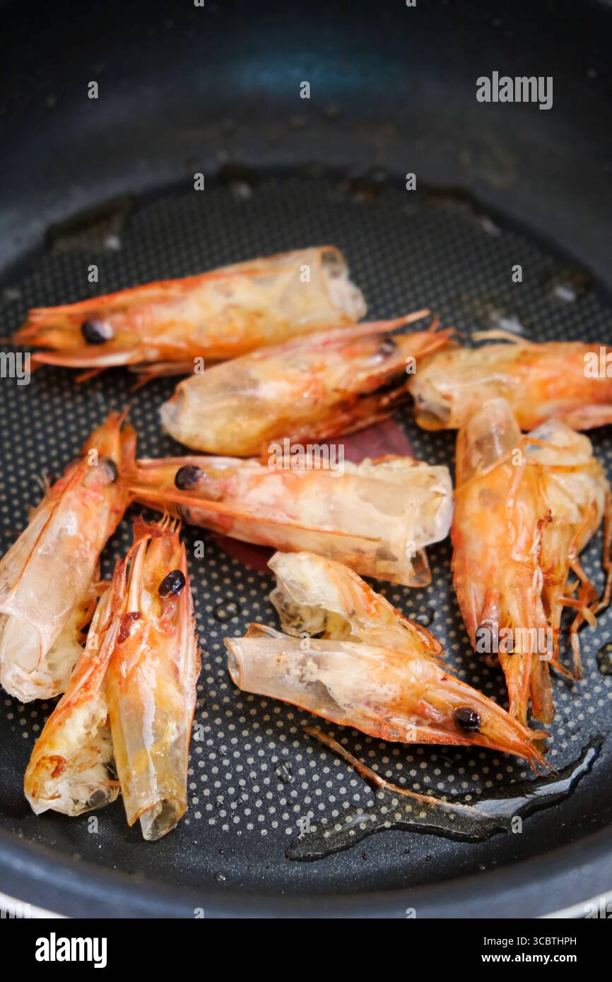 Cuocere la parte della testa dei gamberetti nella padella Foto Stock