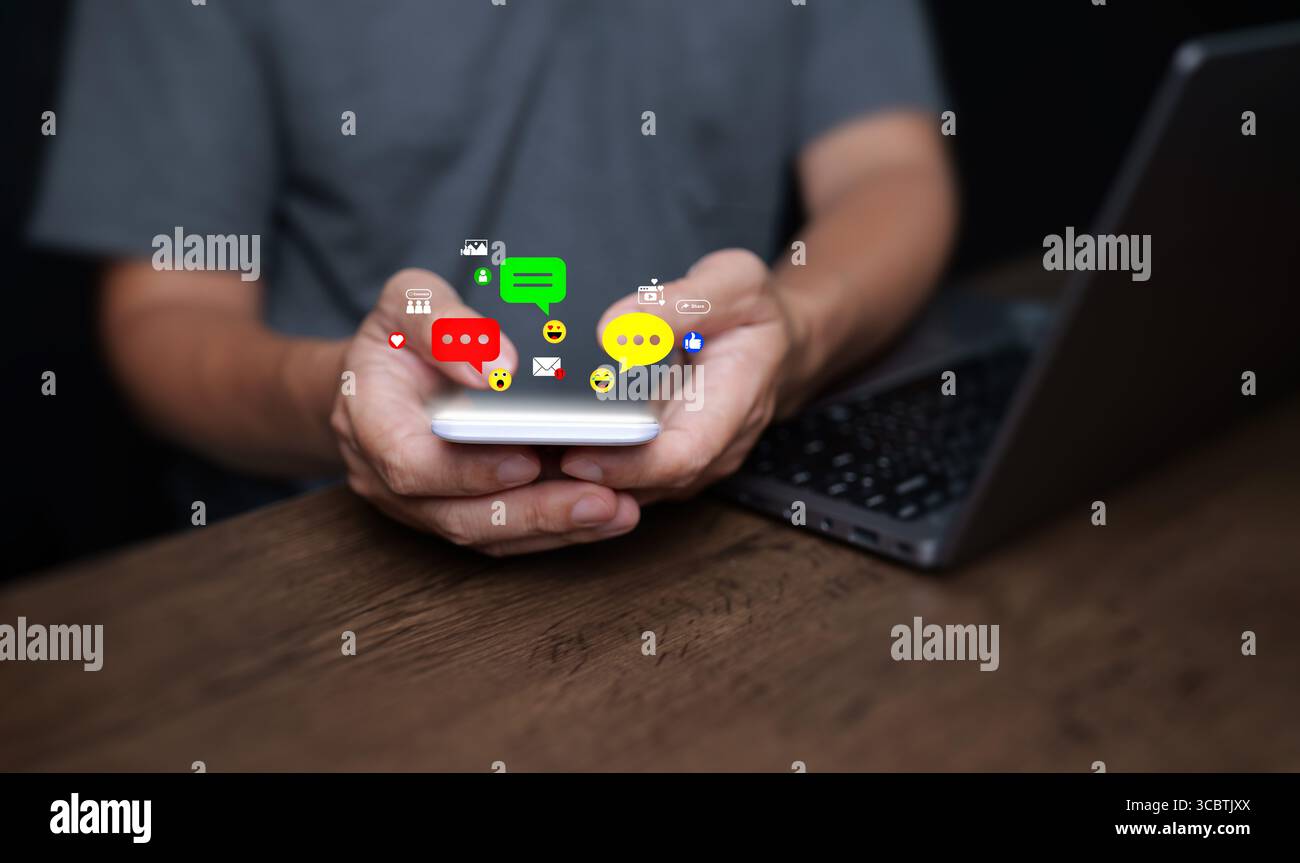 Concetto di social media. Un uomo utilizza lo smartphone con notifiche sui social media, mi piace, cuori, commenti, icone, ed emoticon. Interazione digitale online Foto Stock