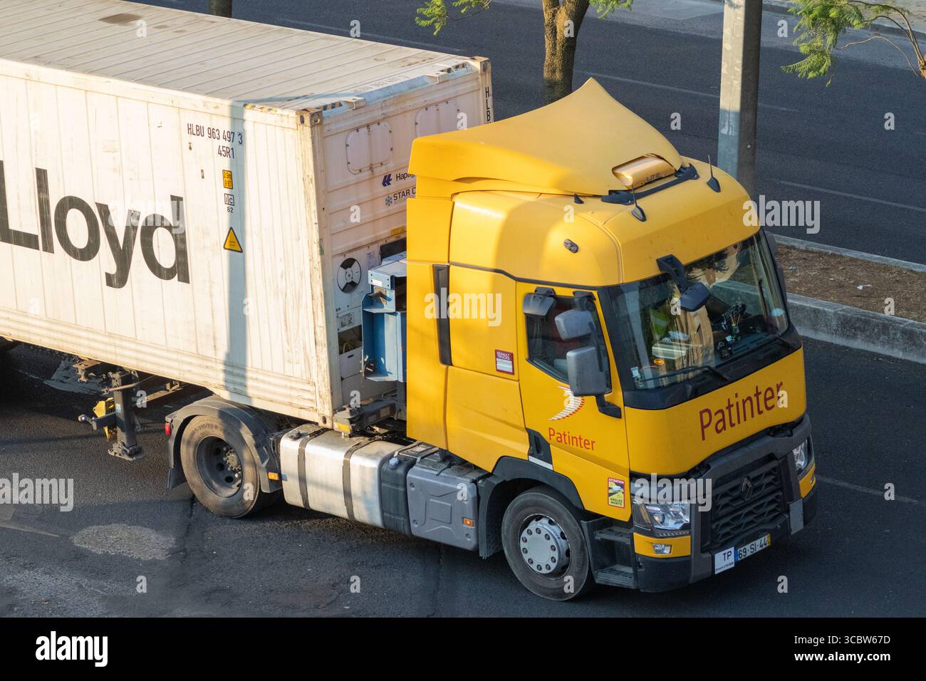 Camion renault con patinter giallo che trasporta un container intermodale hapag lloyd su un'autostrada, visto dall'alto Foto Stock