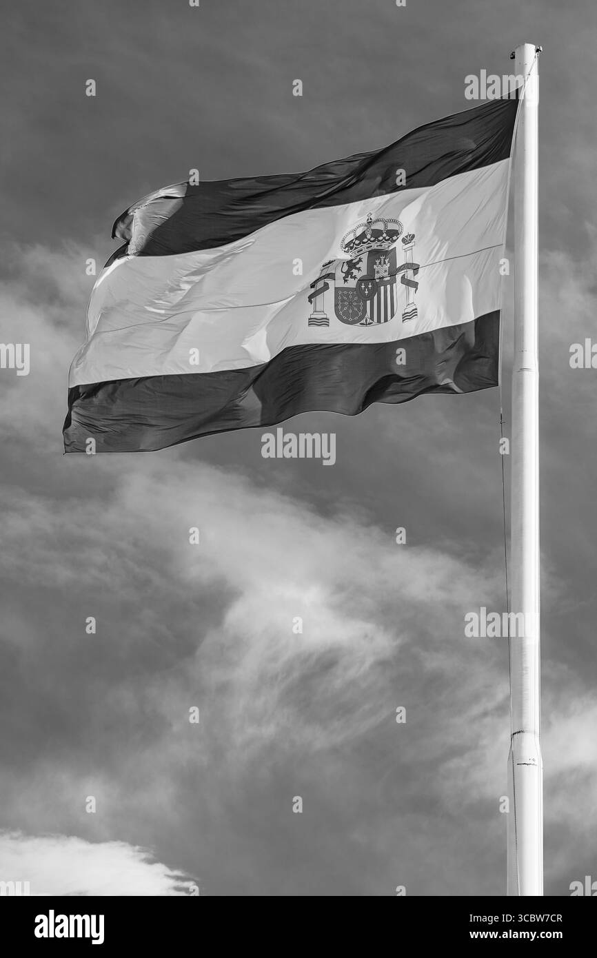 Bandiera nazionale della Spagna che sventola nel vento; bandiera nazionale gialla e rossa in bianco e nero su sfondo nuvoloso del cielo Foto Stock
