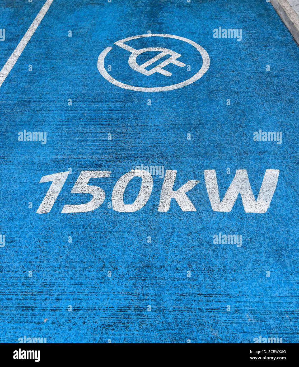Vista dall'alto del piazzale blu della stazione di ricarica per auto elettriche con grafica a spina e segnaletica da 150 kW sul piazzale del garage Foto Stock