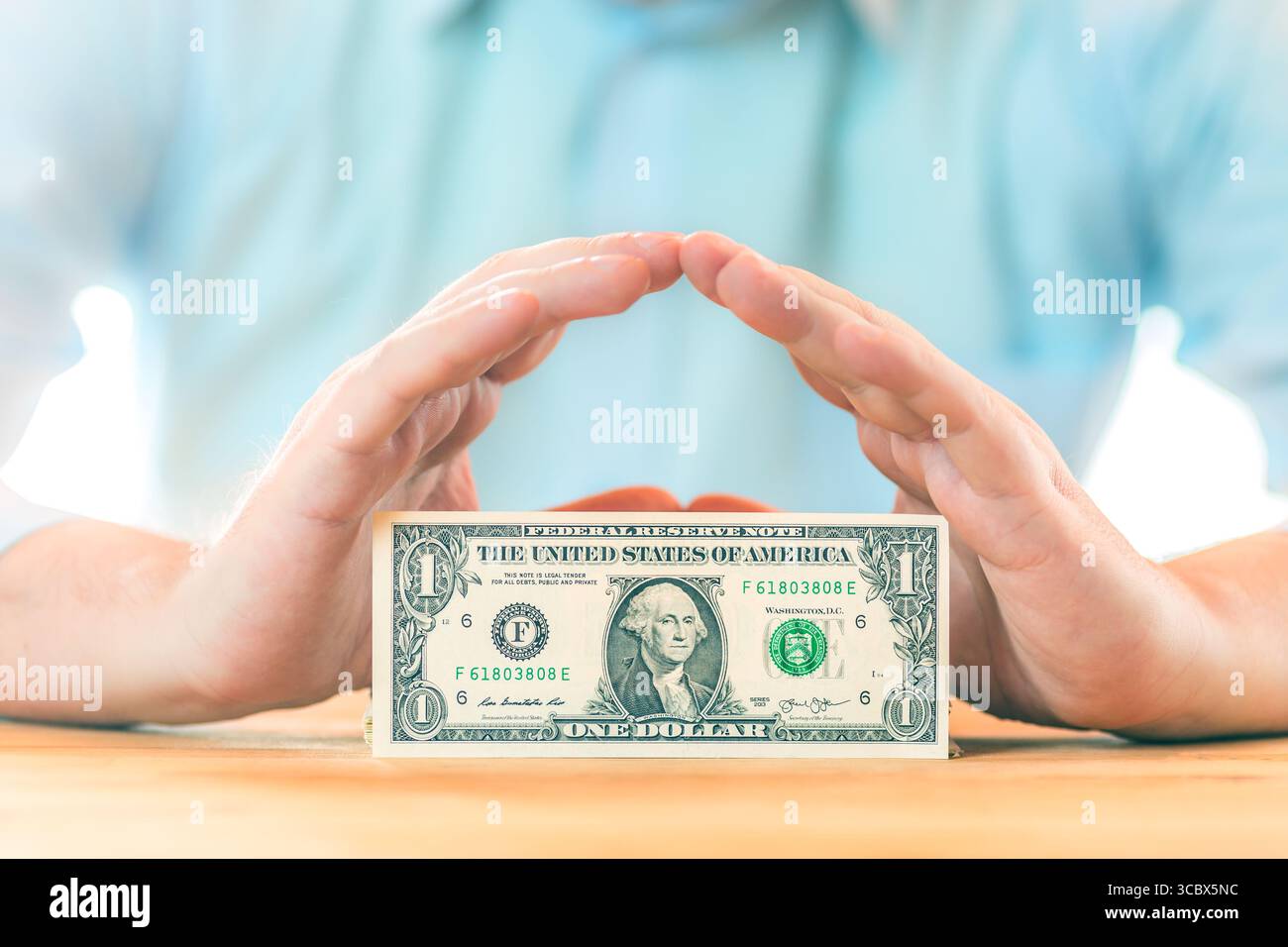 Risparmio di denaro. Concetto di contabilità, business, budget e finanza. Mani maschili sopra una banconota da un dollaro. Foto Stock