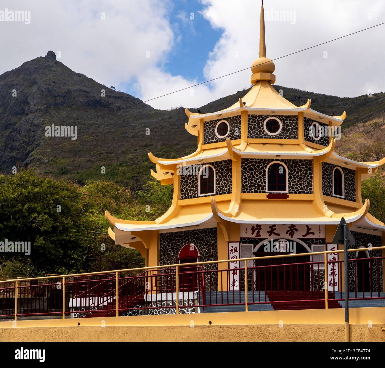 Edificio tempio in stile pagoda giallo con tetto ornato e sfondo di montagna Foto Stock