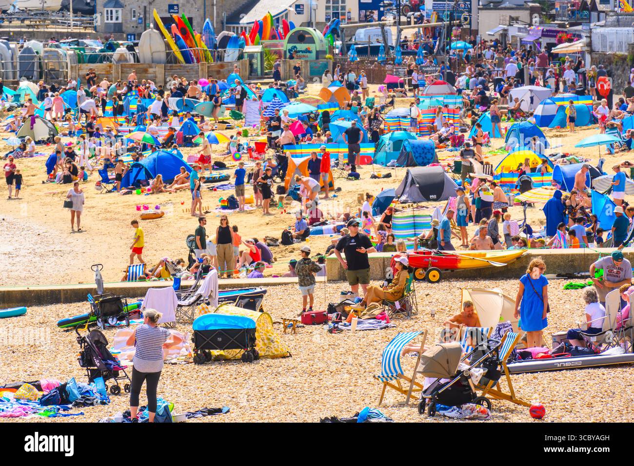 Lyme Regis, Dorset, Regno Unito. 9 agosto 2025. Meteo nel Regno Unito: Folle di turisti e amanti del mare affollano la spiaggia nella località balneare di Lyme Regis per crogiolarsi nel caldo sole ardente durante le vacanze estive scolastiche. Crediti: Celia McMahon/Alamy Live News Foto Stock