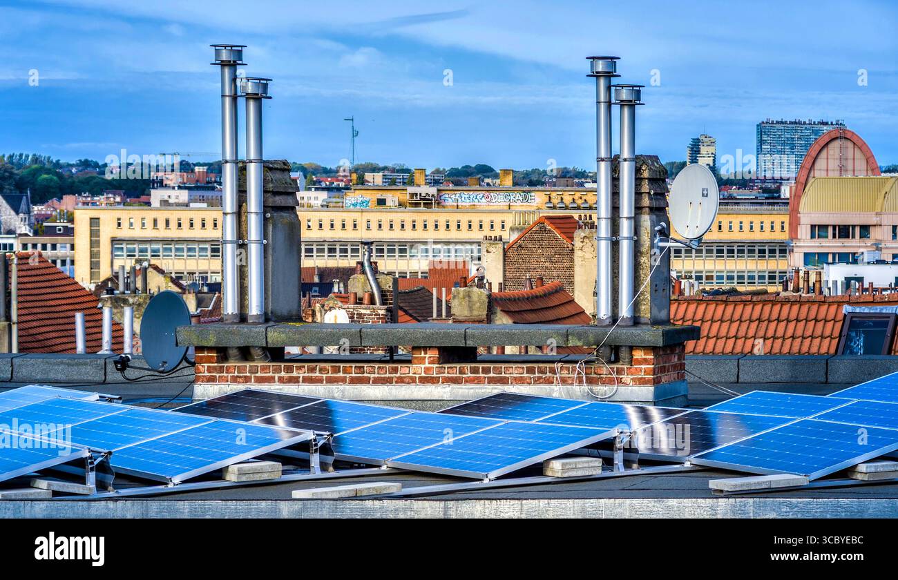 Pannelli solari e prese d'aria condizionata sul tetto del blocco di appartamenti - Saint-Gilles, Bruxelles, Belgio. Foto Stock