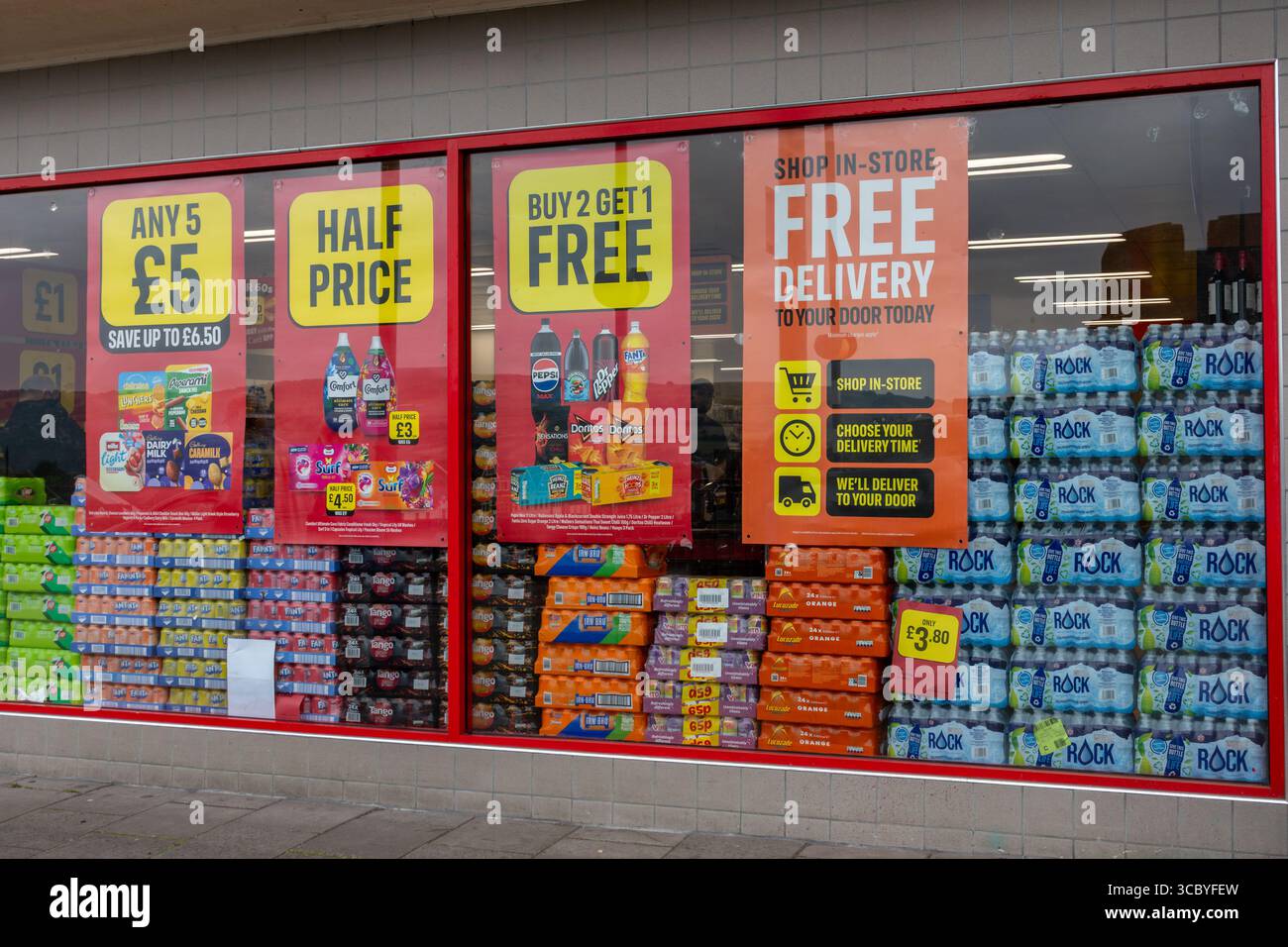 Pile di bibite analcoliche nella vetrina del supermercato Islanda con poster sulle offerte a prezzi ridotti Foto Stock