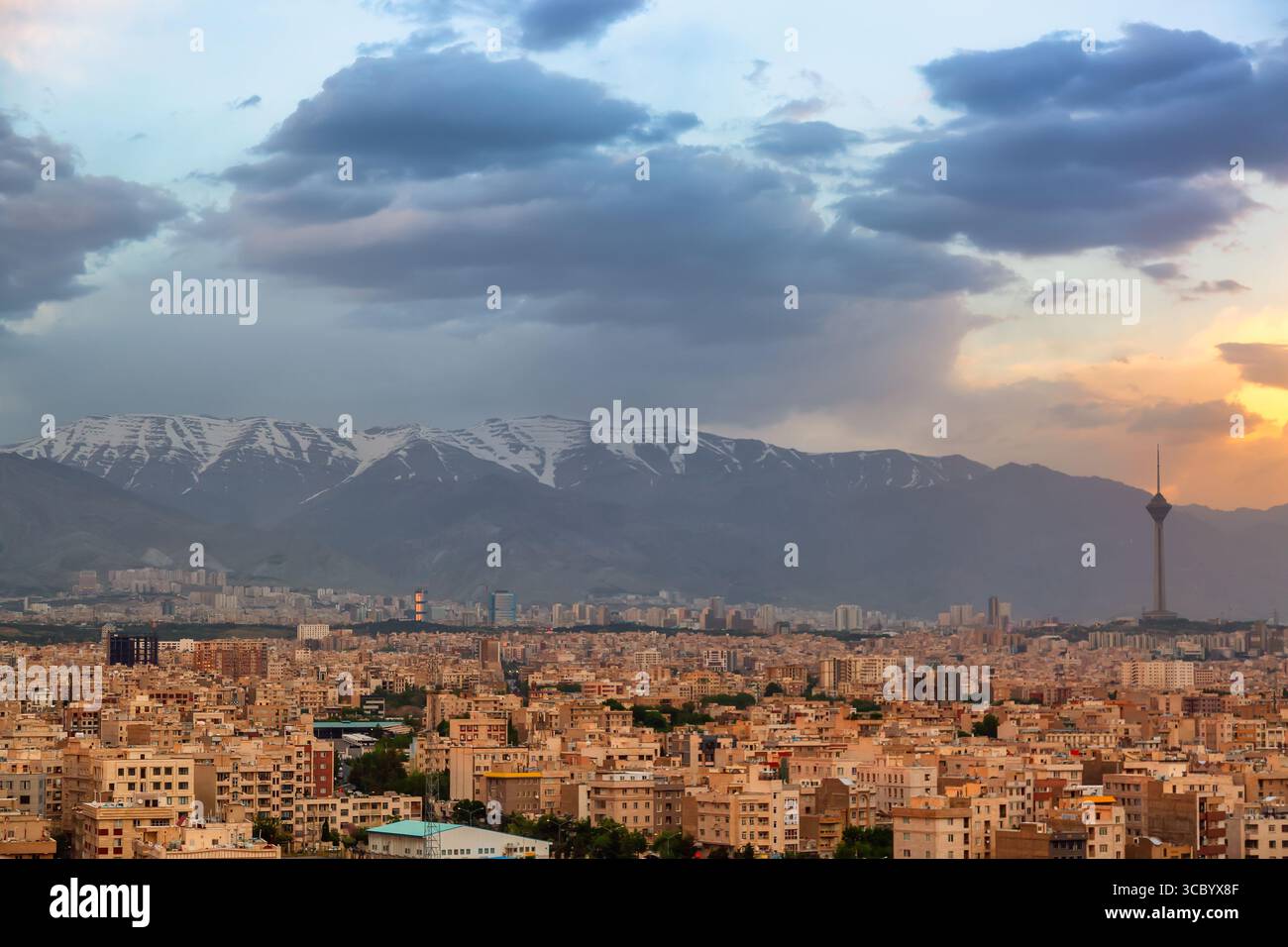 Splendido panorama cittadino al tramonto della città di Teheran, delle montagne e della torre Milad durante il colorato tramonto in Iran. Foto Stock