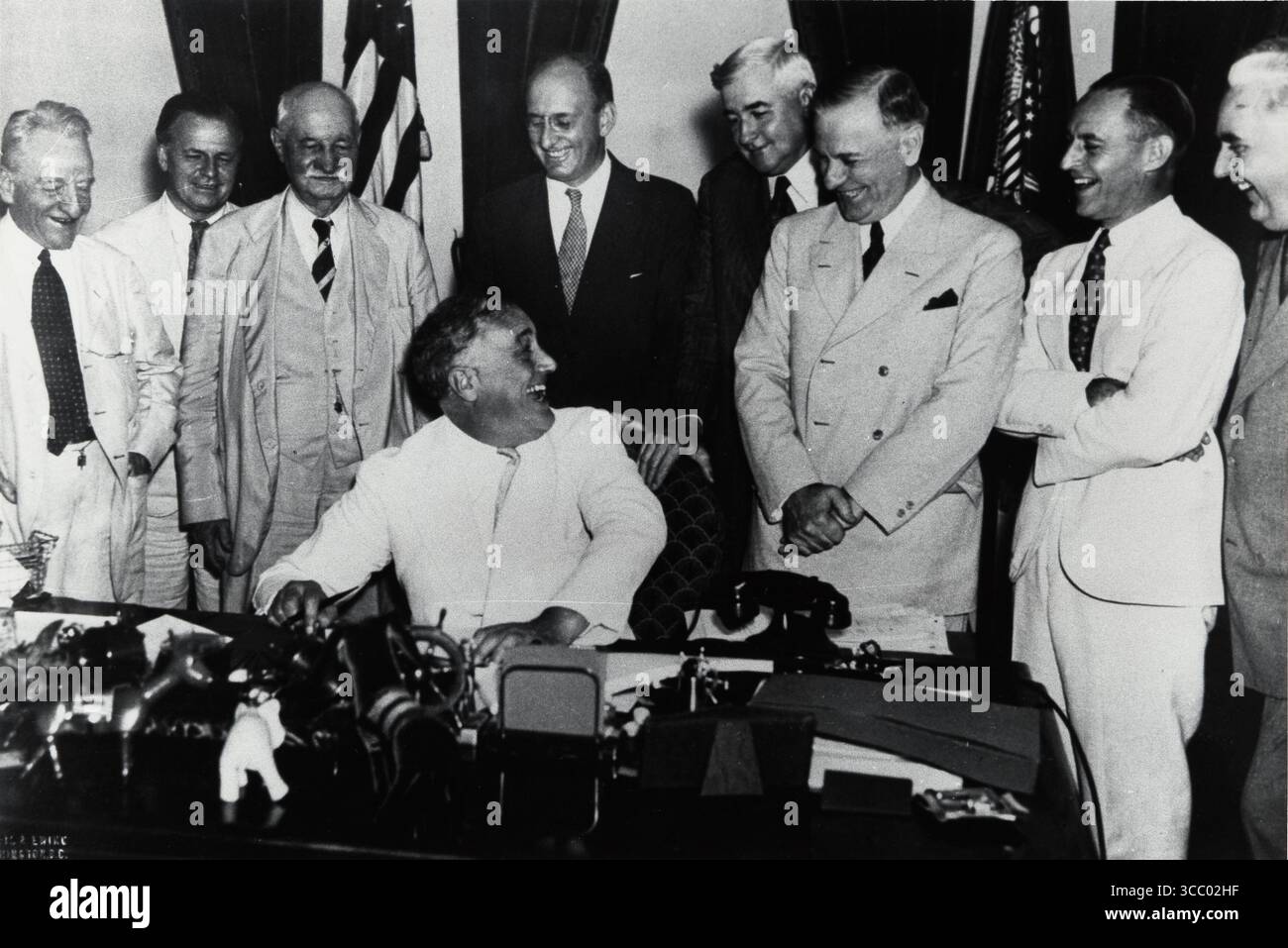 Il Banking Act del 1935 fu firmato dal presidente Roosevelt il 23 agosto, completò la ristrutturazione della Federal Reserve e del sistema finanziario iniziata durante l'amministrazione Hoover e continuò durante l'amministrazione Roosevelt. Da sinistra a destra ci sono un uomo non identificato; il senatore democratico Carter Glass, della Virginia, che aveva parlato contro il disegno di legge; James F. T. o'Conner, Comptroller of the Currency; il senatore democratico Duncan U. Fletcher, della Florida; il segretario al Tesoro Henry Morgenthau; Jesse Jones, il presidente della Reconstruction Finance Corporation (RFC); Alabama Democrat Henry Foto Stock