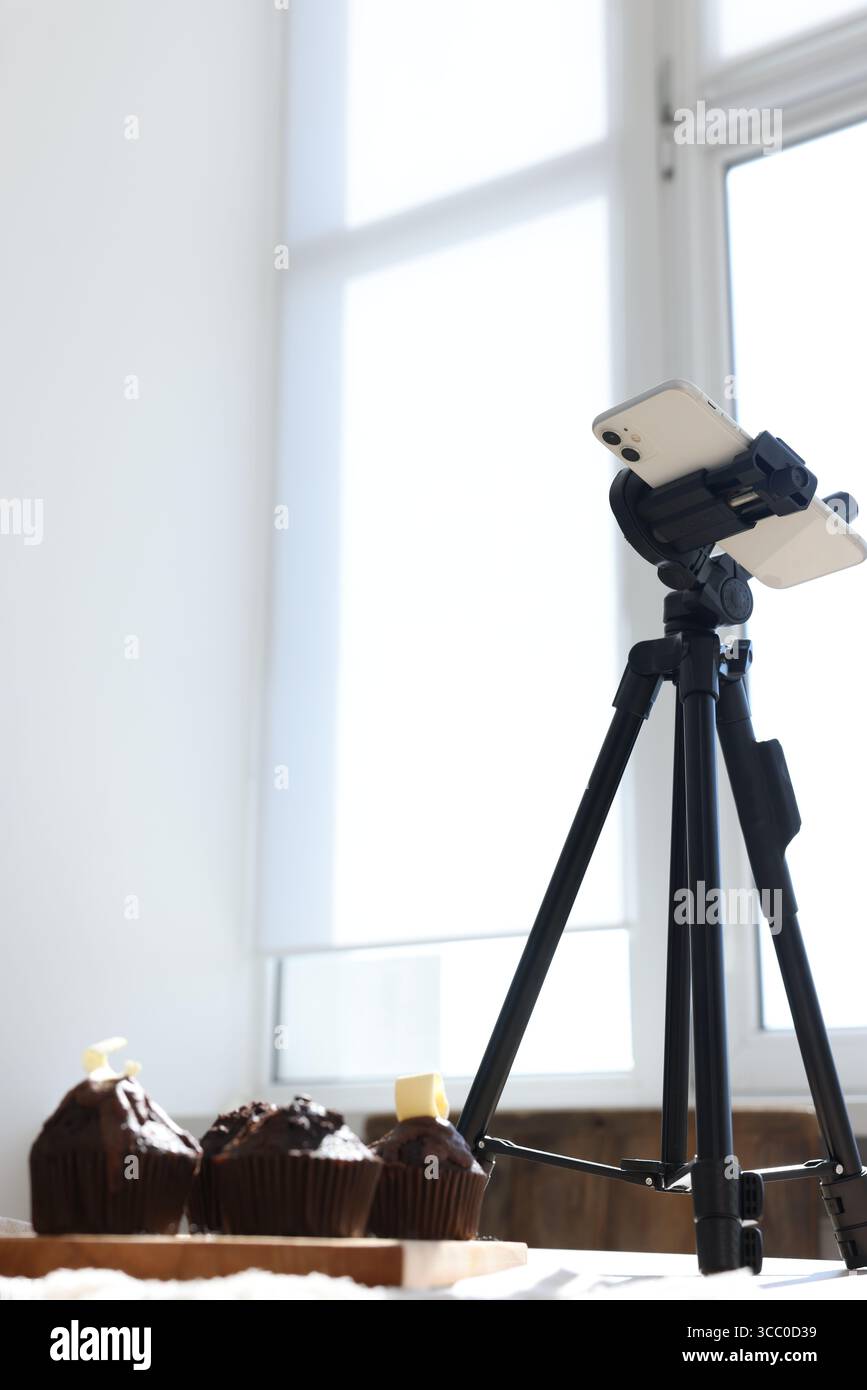 Scatto di muffin al cioccolato con lo smartphone in studio, visuale ad angolo basso. Fotografia gastronomica professionale Foto Stock