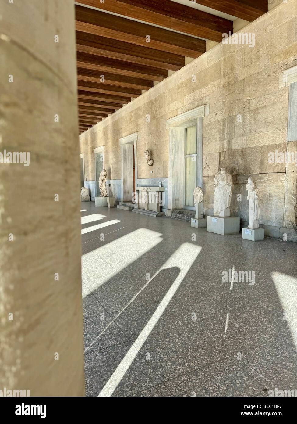 Vedute interne della Stoa di Attalo ad Atene, Grecia, con colonnati classici e antiche sculture sotto la luce naturale del sole. - Immagine stock catturata con smartphone