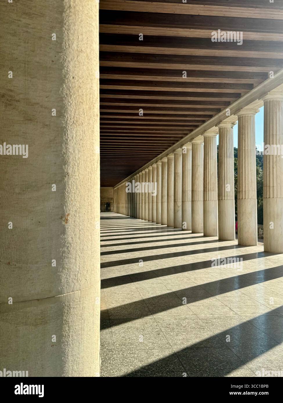 Vedute interne della Stoa di Attalo ad Atene, Grecia, con colonnati classici e antiche sculture sotto la luce naturale del sole. - Immagine stock catturata con smartphone