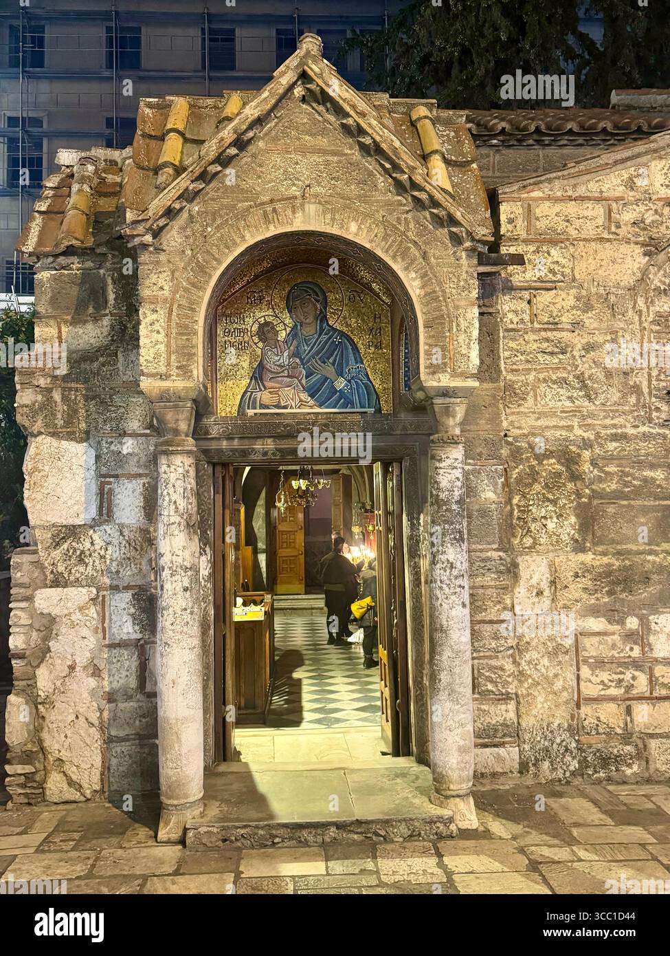 Entrata illuminata della Chiesa di Panagia Kapnikarea ad Atene, caratterizzata da un mosaico bizantino sopra la porta. - Immagine stock catturata con smartphone