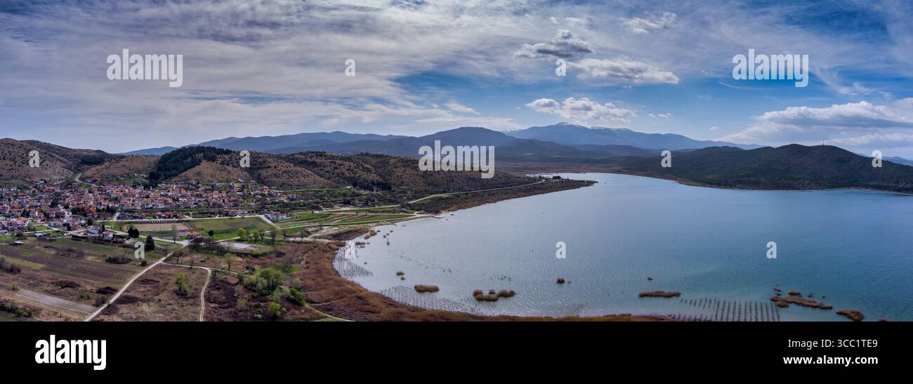 Vista aerea di Arnissa, Grecia, con il lago Vegoritida accanto alla città. Circondato da colline e montagne, questo tranquillo paesaggio fonde natura e tra Foto Stock