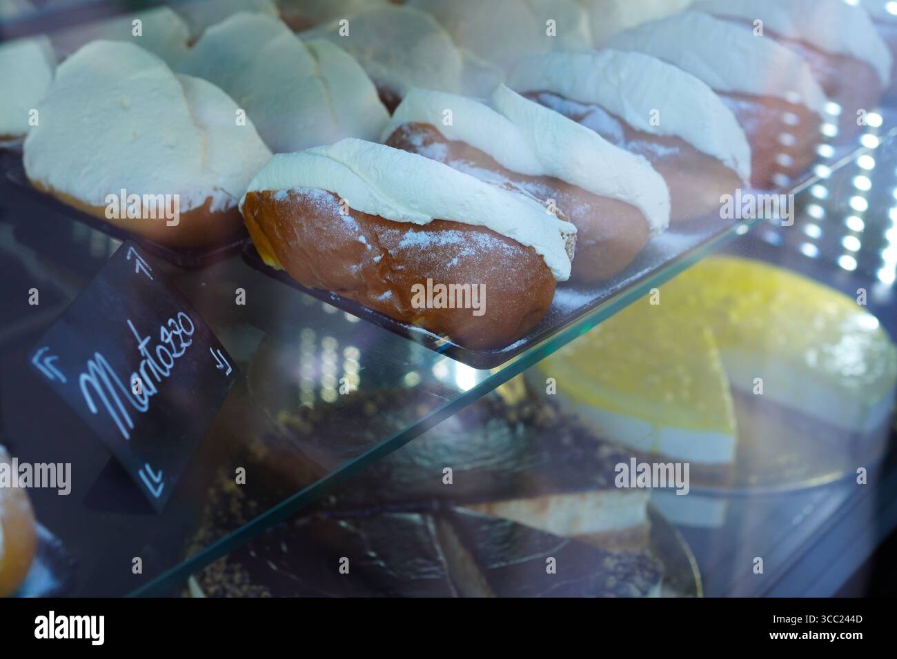 Specialità romane dolci maritozzo e maritozzo con crema di pistacchio nella vetrina di una pasticceria a Roma, Italia Foto Stock