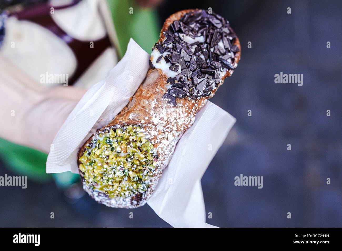 Giovane donna italiana che tiene in mano un dolce cannoli di strada italiano Foto Stock