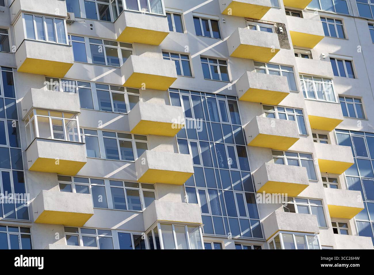 Facciata di un edificio a più piani in costruzione illuminato dal sole. Costruzione Foto Stock