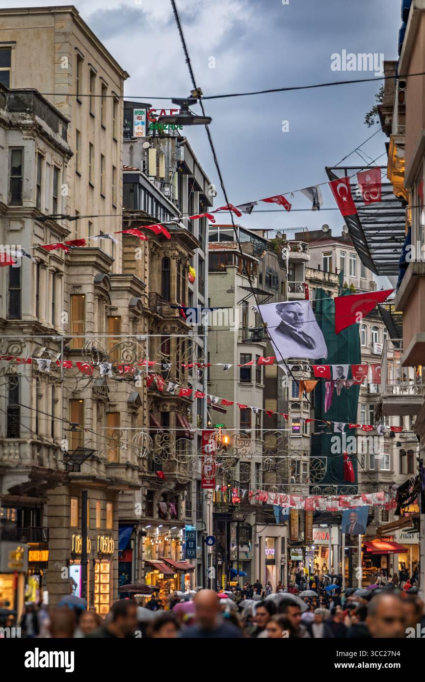 Istanbul, Turchia - 11 novembre 2023: Una vista sull'affollato viale Istiklal con edifici storici bandiere turche e un grande ritratto di Ataturk a Taksim Foto Stock