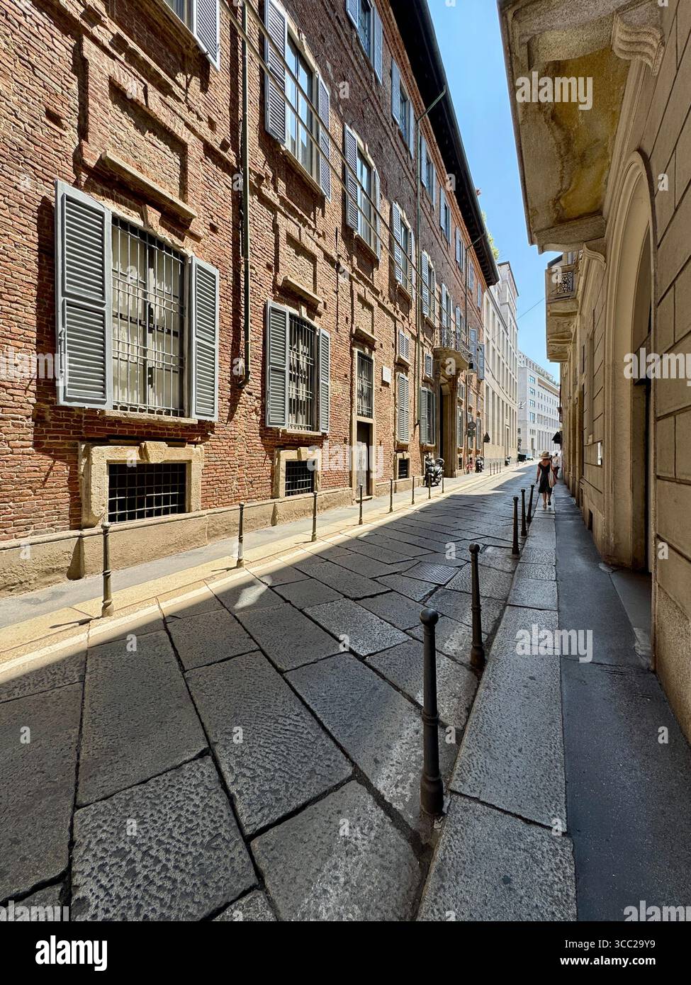 Storica strada acciottolata con vecchi edifici in mattoni e persiane a Milano, Italia, paesaggio urbano estivo. - Immagine stock catturata con smartphone