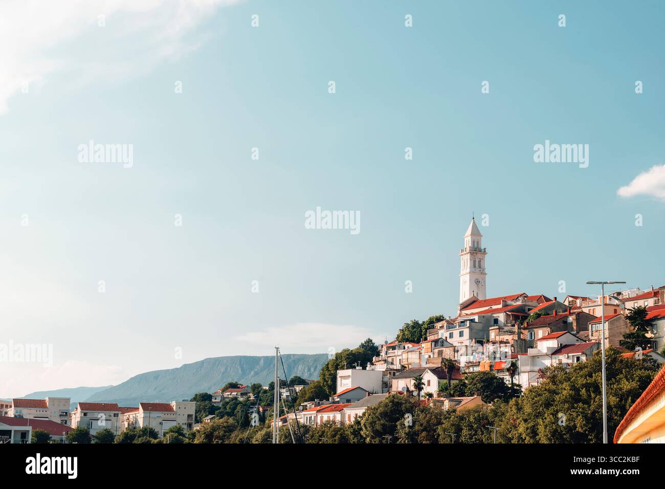 Villaggio con tetti rossi e torre bianca sotto il cielo azzurro. Novi Vinodolski, Croazia. Foto Stock
