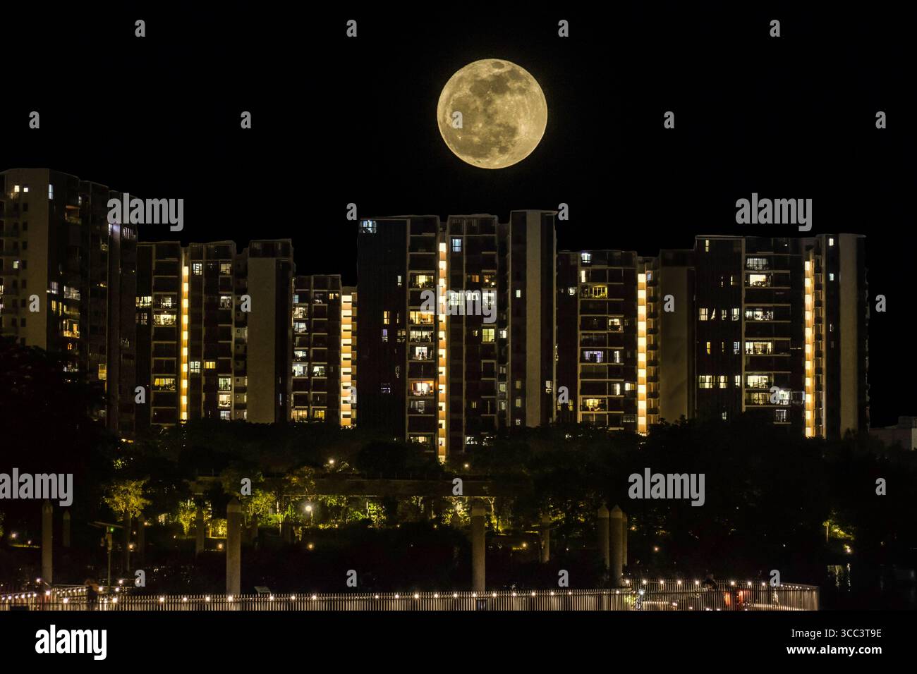 La luna piena di Sturgeon si innalza sul lago Jurong nella parte occidentale di Singapore il 9 agosto 2025. Foto Stock