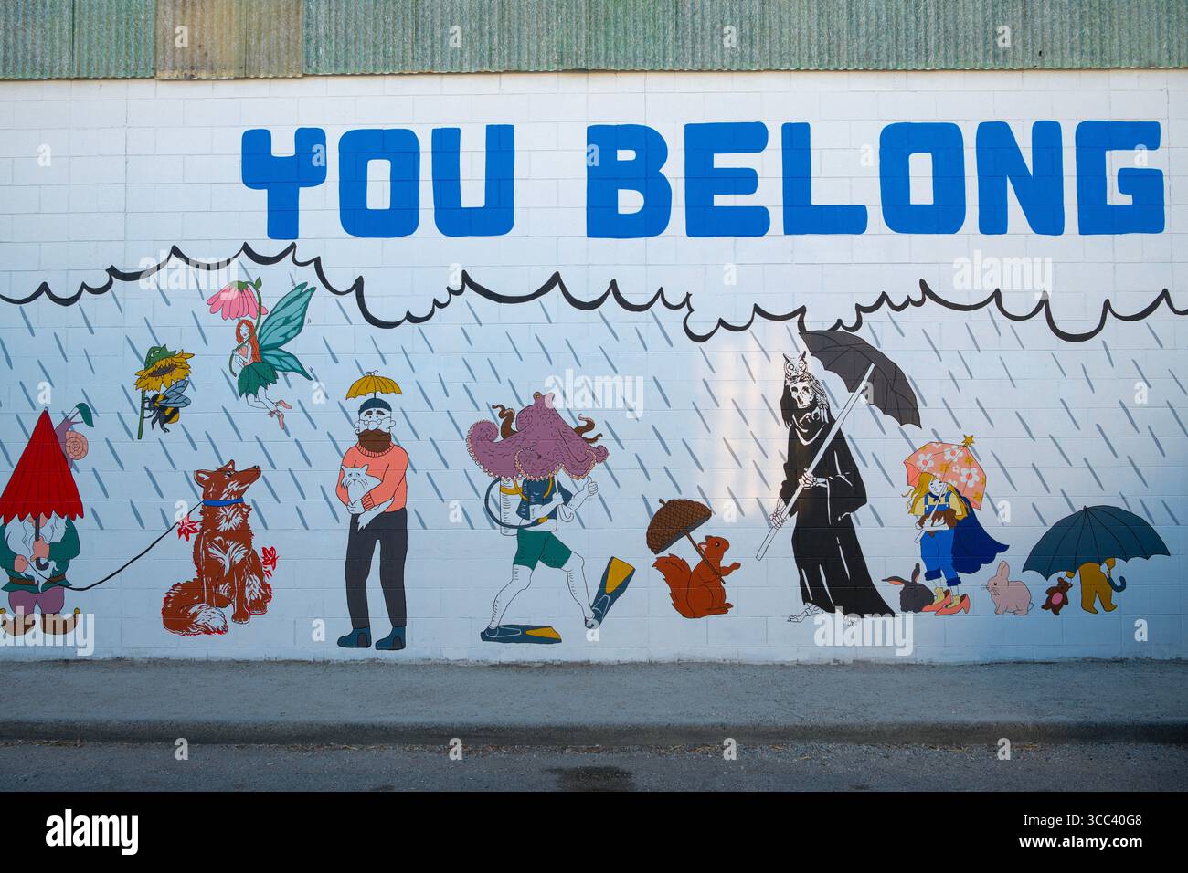 Un murale lungo un marciapiede vuoto a East Vancouver, British Columbia. Foto Stock