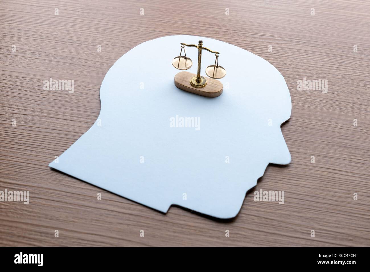 Un ritaglio di carta di una testa umana con scala di giustizia. Giudizio, etica, moralità, equilibrio, legge, e il concetto decisionale. Foto Stock