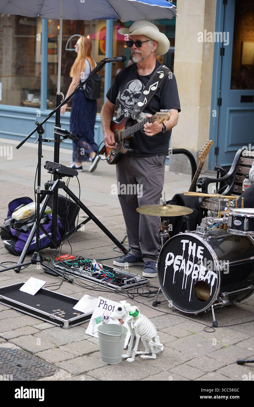 Street Performer che suona la chitarra con scheletro decorativo e Drum Kit. Salisbury, Inghilterra Foto Stock