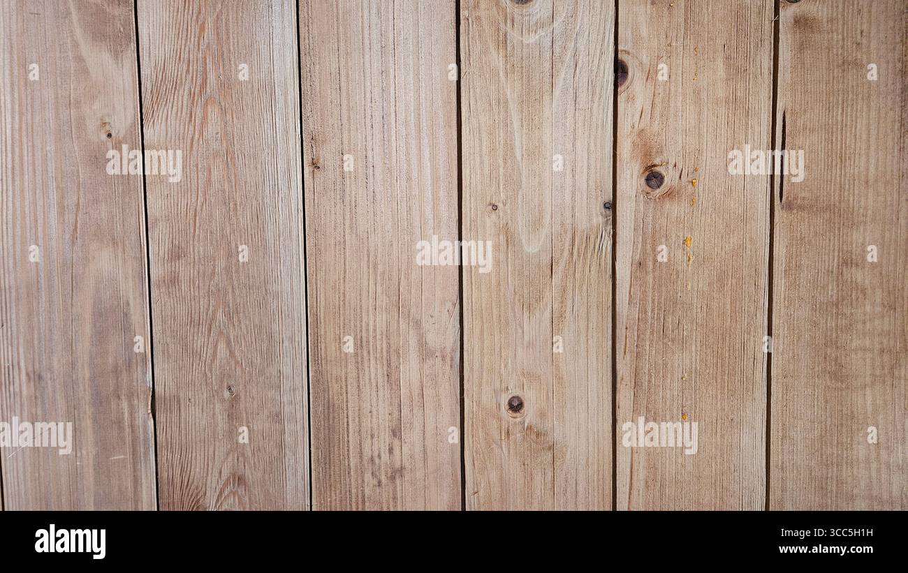 Primo piano di assi verticali in legno con grana visibile, nodi e imperfezioni naturali, che presentano una texture rustica e organica ideale per gli sfondi - Immagine stock catturata con smartphone