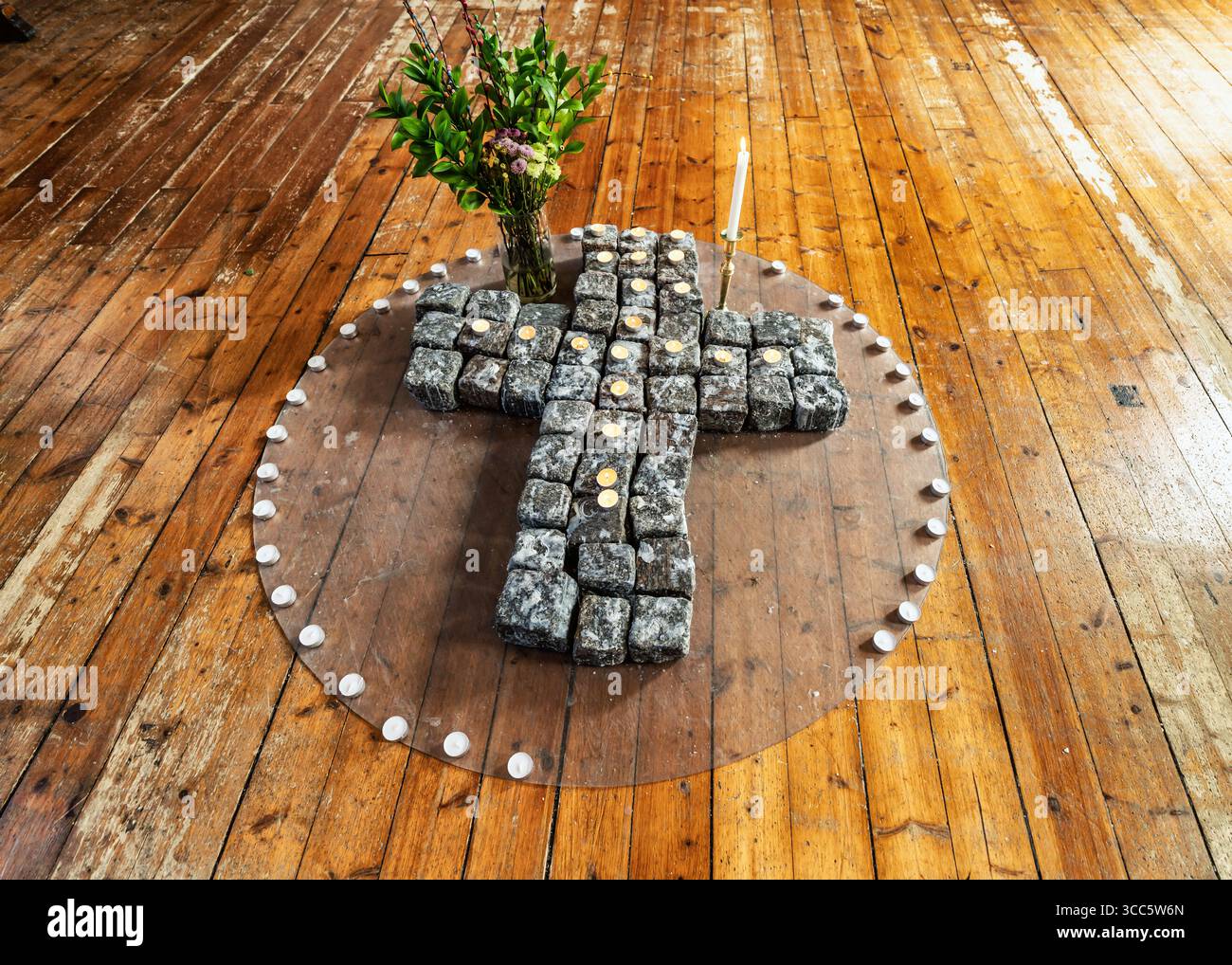 L'interno di una chiesa storica presenta un colorato altare e tradizionali pali di legno, completato da vibranti opere d'arte e intricati elementi decorativi Foto Stock