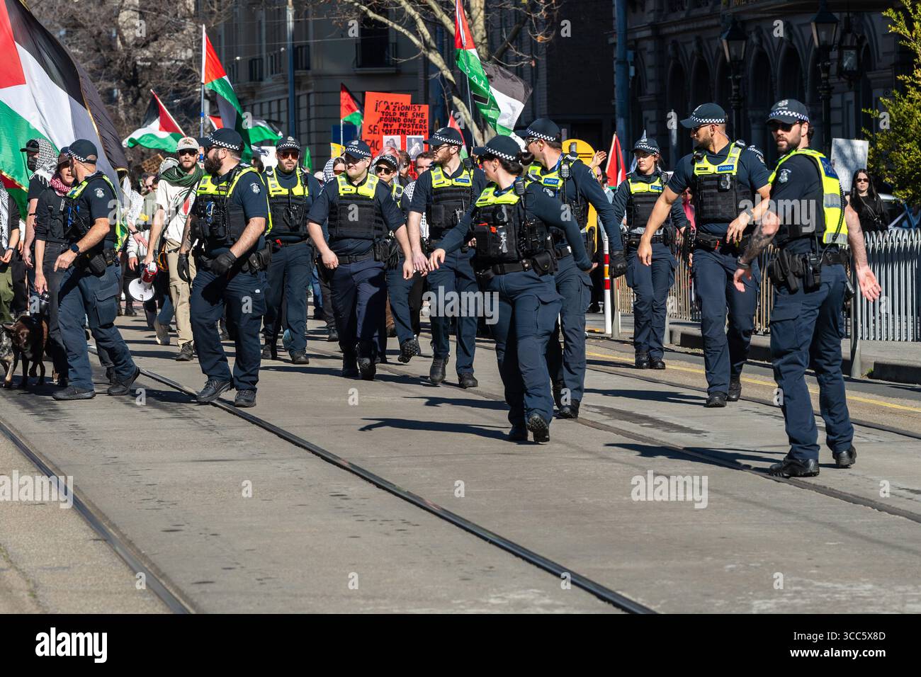 La polizia di Victoria corre per formare una linea di manifestanti pro-Palestina durante una manifestazione. I manifestanti pro-Palestina e pro-Israele si avvicinarono a una faccia a Melbourne, provocando una grande risposta della polizia Victoria, che includeva l'ordine pubblico, gli ufficiali a cavallo e gli ufficiali di servizio generale. Il raduno pro-Palestina, che ha visto un numero stimato di oltre mille partecipanti, ha marciato attraverso il CBD chiedendo un cessate il fuoco a Gaza, mentre meno di 10 membri del gruppo filo-israeliano Lions of Sion hanno tenuto una contro-dimostrazione. La polizia formò delle linee per tenere separati i gruppi, con diversi scambi di tensione e arresti avvenuti durante la e Foto Stock