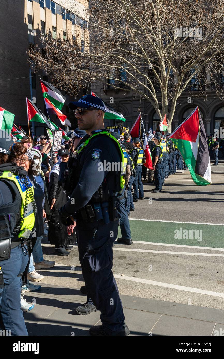 La polizia forma una linea per bloccare i manifestanti pro-palestinesi contro Israele durante i raduni opposti a Melbourne, impedendo uno scontro diretto tra i gruppi. I manifestanti pro-Palestina e pro-Israele si avvicinarono a una faccia a Melbourne, provocando una grande risposta della polizia Victoria, che includeva l'ordine pubblico, gli ufficiali a cavallo e gli ufficiali di servizio generale. Il raduno pro-Palestina, che ha visto un numero stimato di oltre mille partecipanti, ha marciato attraverso il CBD chiedendo un cessate il fuoco a Gaza, mentre meno di 10 membri del gruppo filo-israeliano Lions of Sion hanno tenuto una contro-dimostrazione. La polizia ha creato delle linee per tenere il Foto Stock