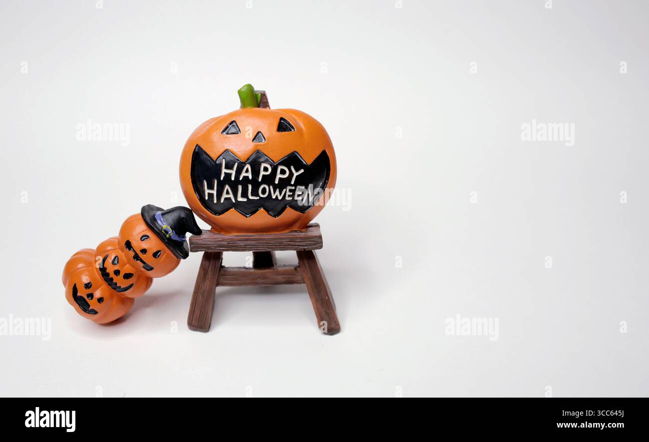 Le zucche arancioni spaventose e sorridono modellano e impilano le zucche per decorare il giorno di halloween su sfondo bianco Foto Stock