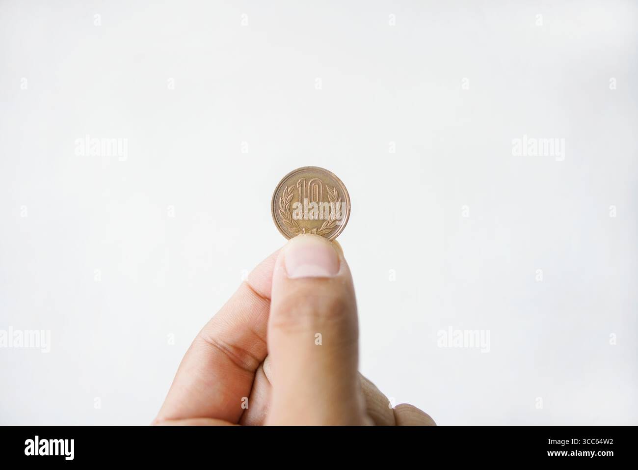 10 monete in valuta giapponese Yen a disposizione, tasso d'imposta al consumo giapponese fino al 10%, hanno un effetto sul viaggiatore in Giappone su sfondo bianco Foto Stock