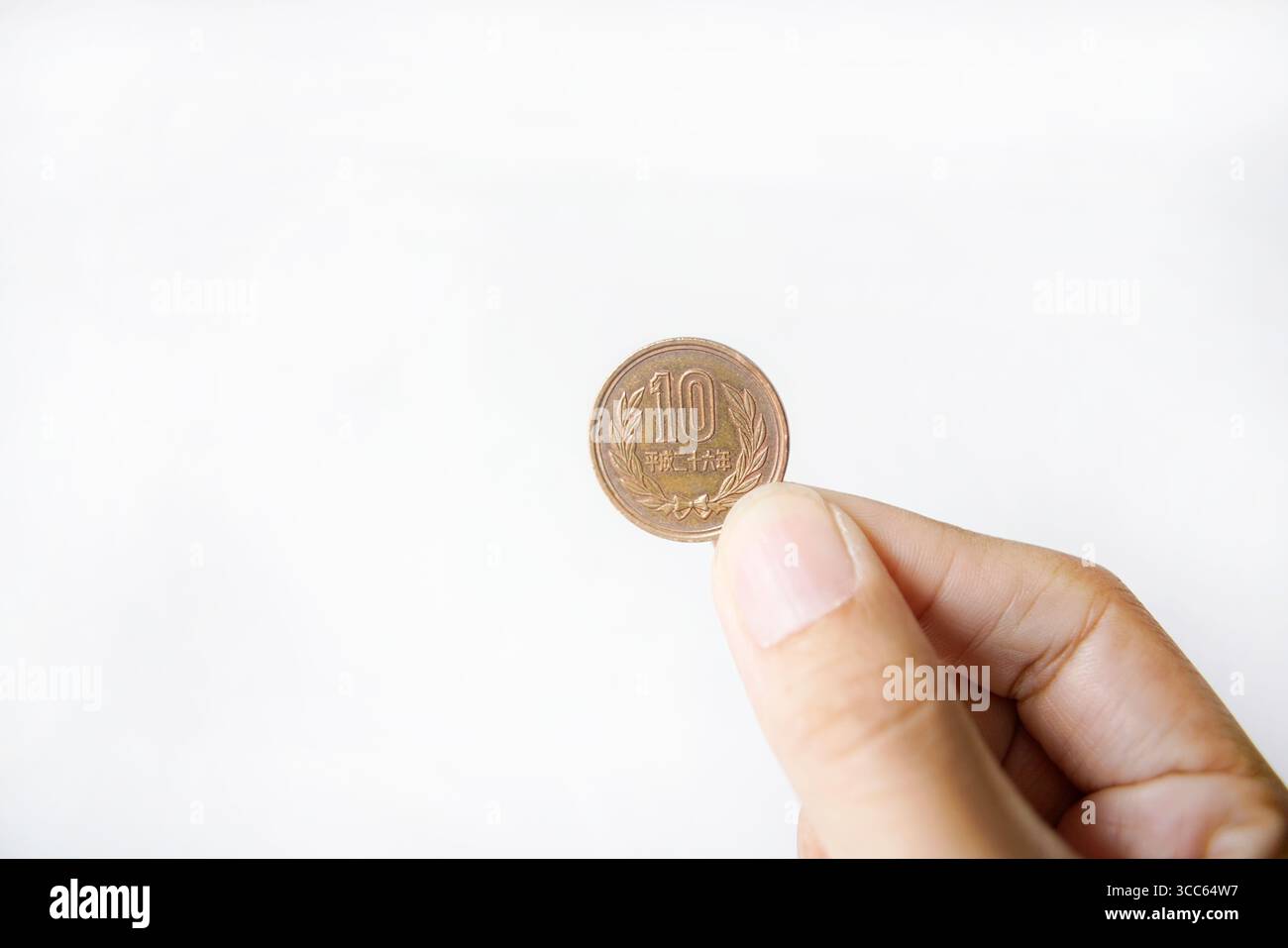 Monete giapponesi da 10 yen su sfondo bianco. Foto Stock