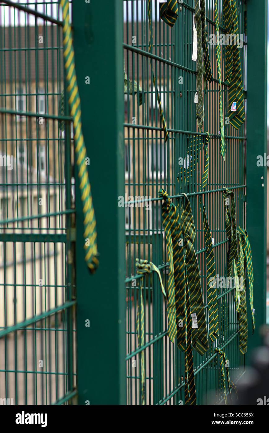 I legami scolastici pendono da una recinzione metallica, simboleggiando la fine dell'anno scolastico Foto Stock