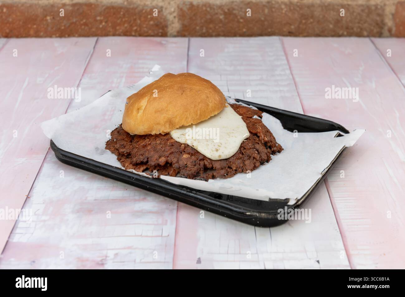 Food Porn Burger: Un flusso di formaggio fuso che collega l'hamburger con patatine fritte soffocate in salsa barbecue Foto Stock