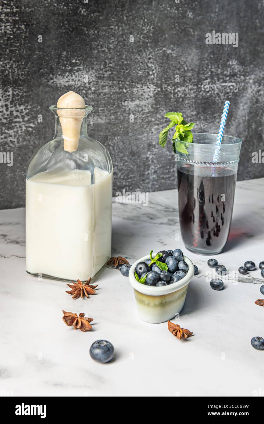 Vivace frullato di mirtilli: Una ricca miscela di frutti di bosco, yogurt greco e miele, guarnito con mirtilli freschi e un pizzico di menta per un colorato cont Foto Stock