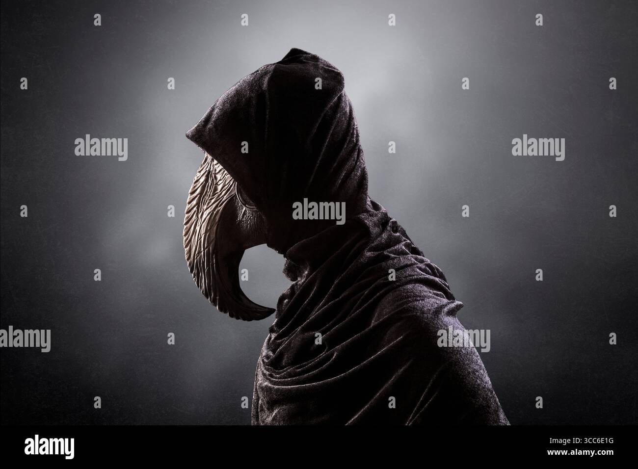 Figura inquietante con lunga maschera a becco di uccello in mantello con cappuccio di notte su sfondo scuro e nebbioso Foto Stock