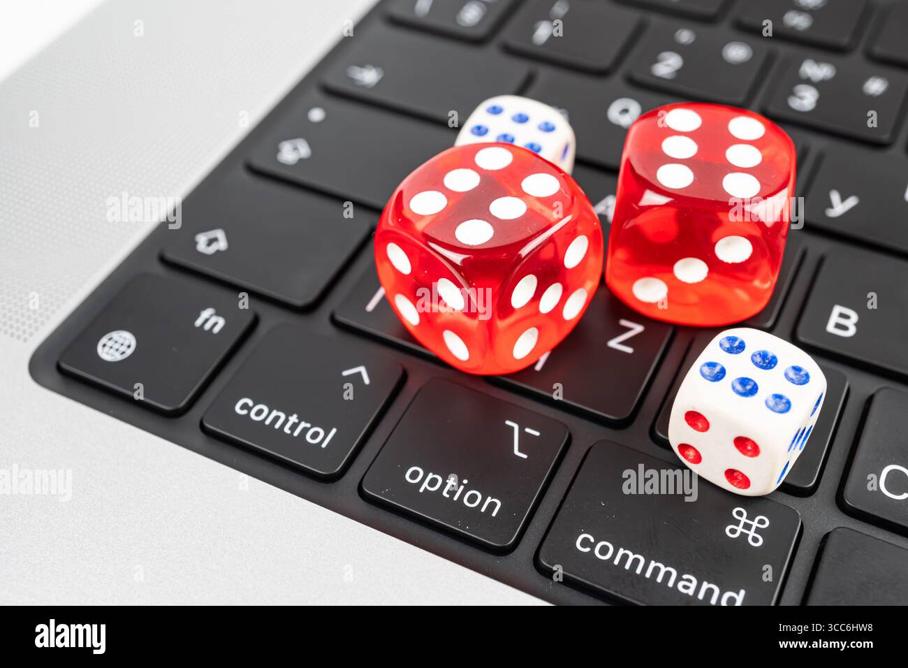 Tre dadi colorati su una tastiera per computer con punti da 1 a 6 scena adatta per la tecnologia, il gioco d'azzardo, i giochi o il marketing decisionale Foto Stock