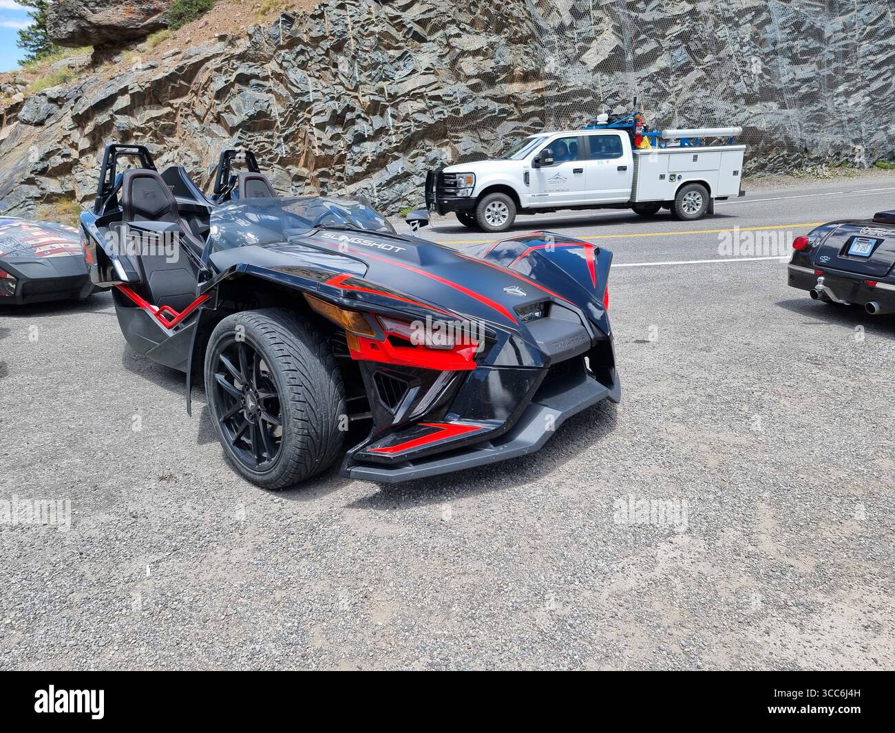 Polaris Slingshot nero e rosso: Motocicletta a 3 ruote, parcheggiata lungo una strada di montagna Foto Stock