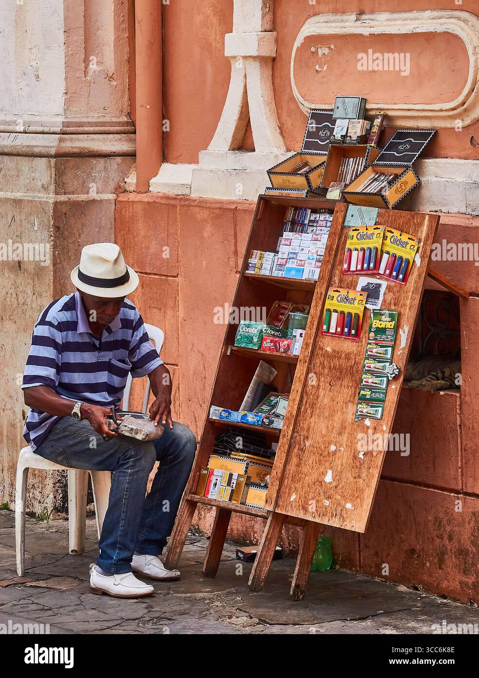 Venditore ambulante a Salvador, Brasile, che espone vari articoli in vendita su una pavimentazione cittadina Foto Stock