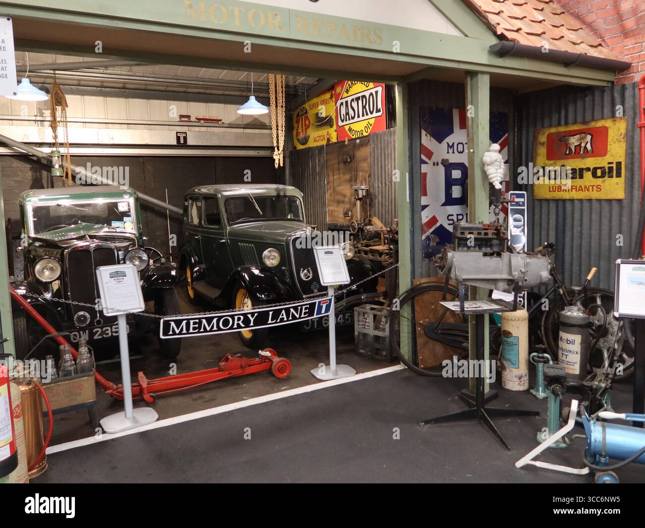 Un viaggio lungo la corsia della memoria: Un garage vecchio stile per la riparazione di veicoli e marchi pubblicitari; in mostra al museo automobilistico Atwell-Wilson. Foto Stock